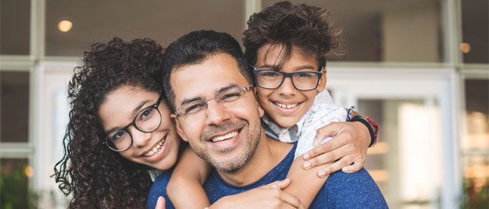 Man holding 2 kids on his back